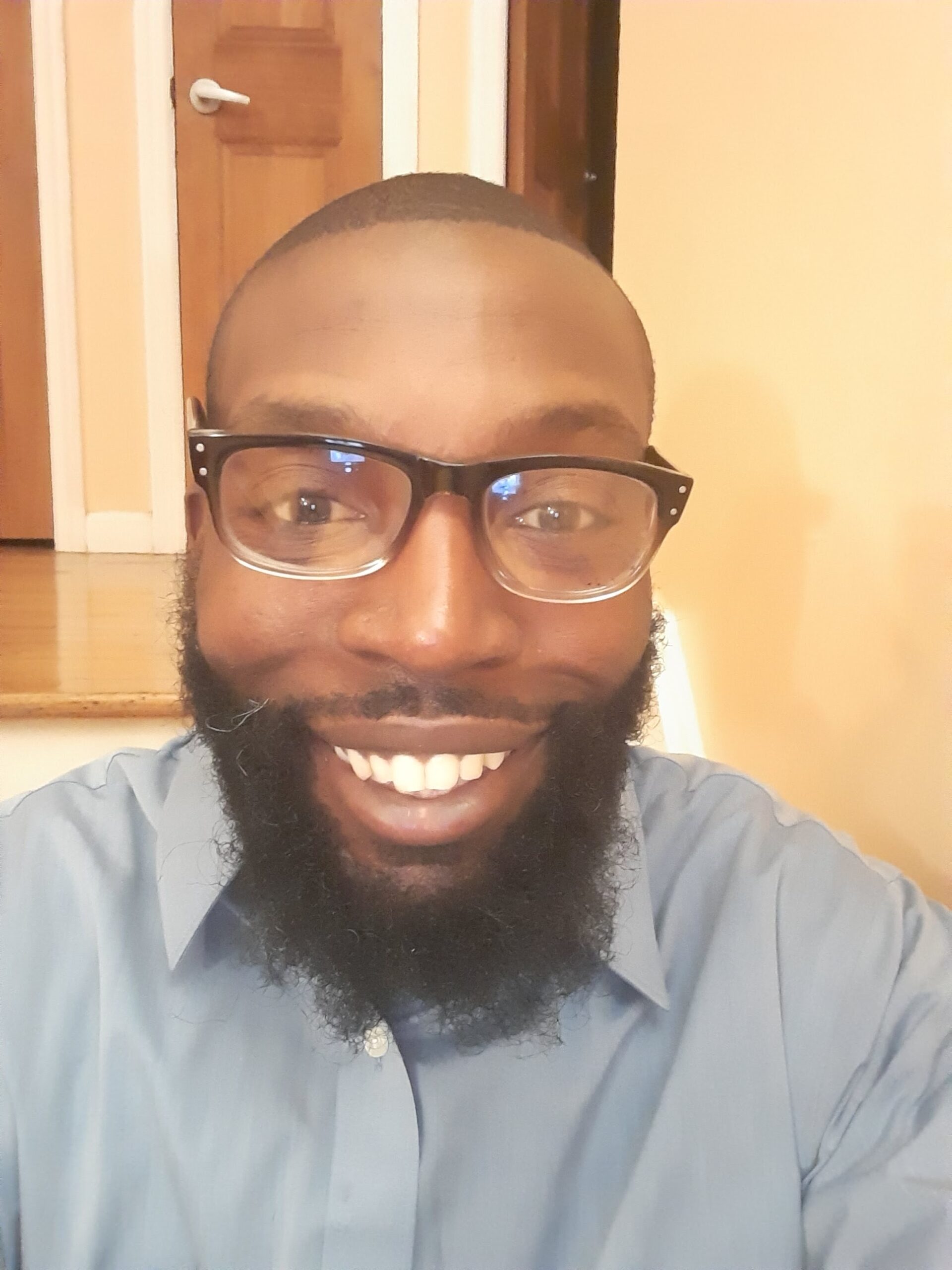 A man with a beard and glasses smiling